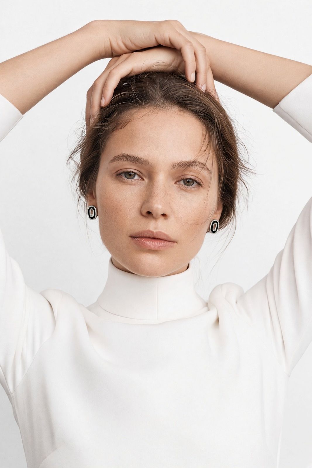 Onyx Héritage earrings worn with a white high collar